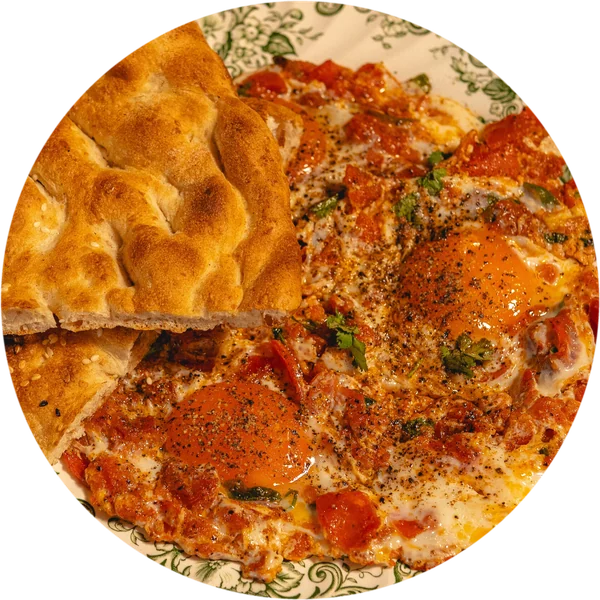 Yad e Watan, afghanisches Frühstück mit Eiern in Tomaten und Fladenbrot auf einem grünen Vintage-Teller